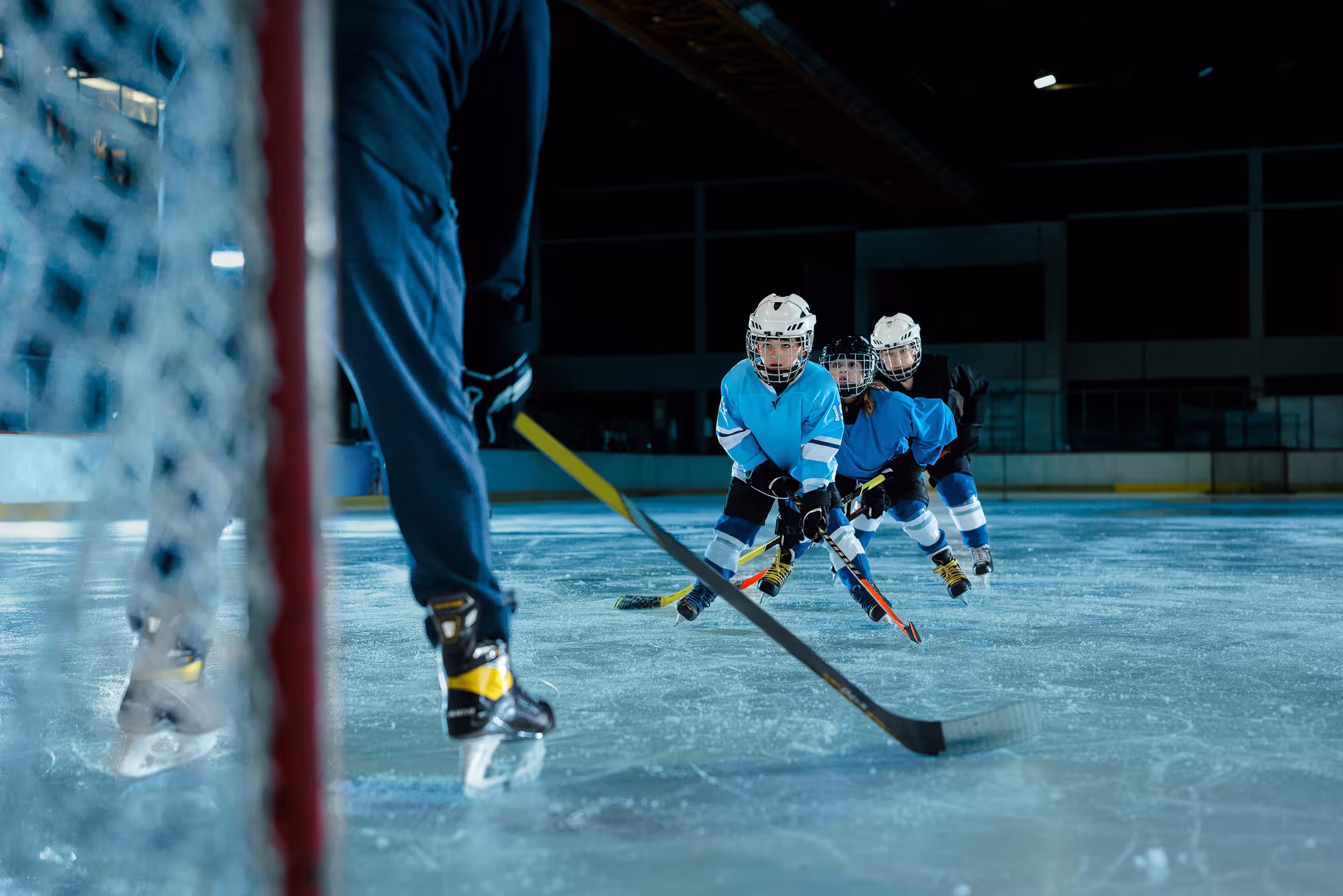 Kids playing hockey on ice rink